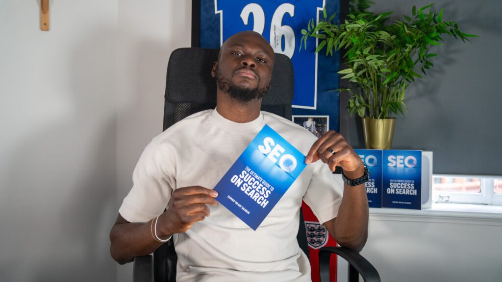 a man sitting in a chair holding a blue sign